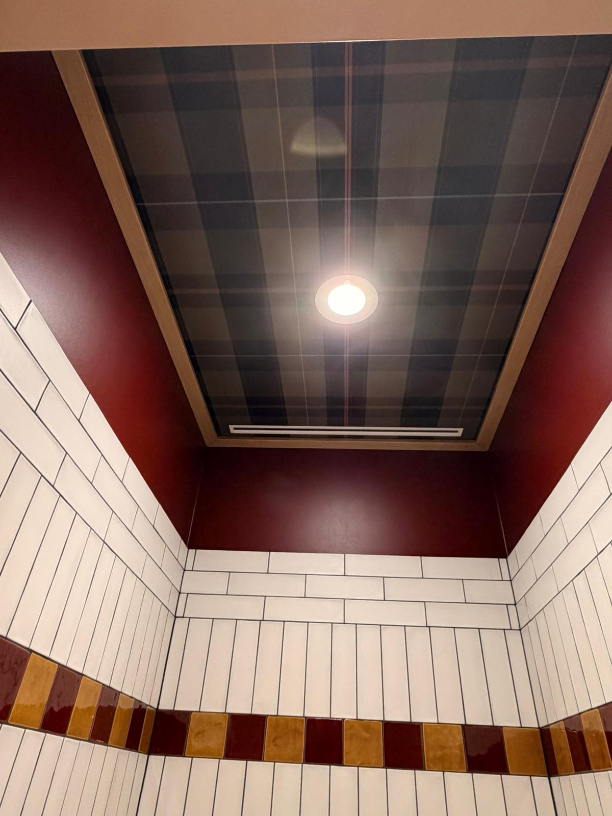 Plafondvak met tartan-behang boven witte tegels en mozaïekvloer