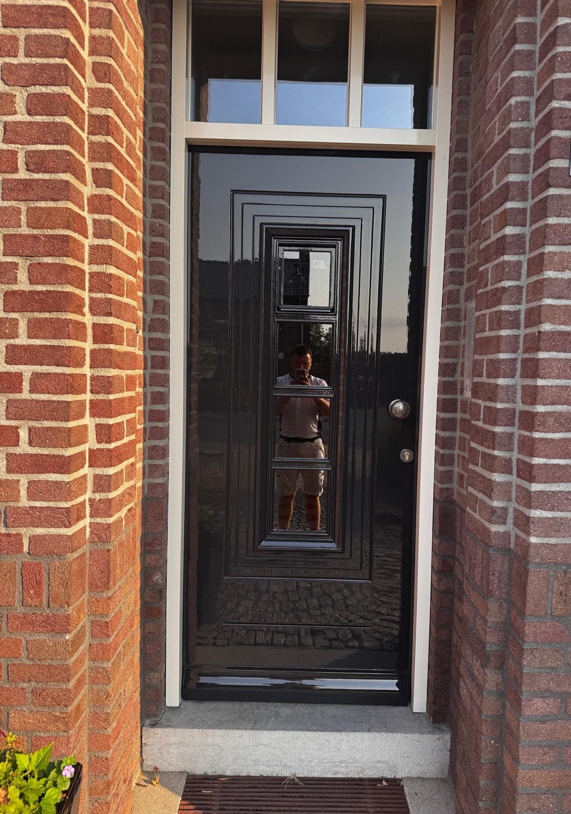 Hoogglans zwart geschilderde voordeur en kozijn in Roermond